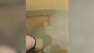 Glass dildo in bathtub