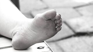 Women's feet on a park bench.